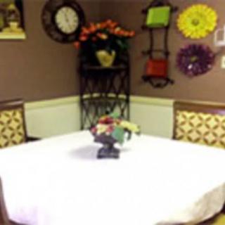 A cozy dining room with a white tablecloth and colorful wall decorations.