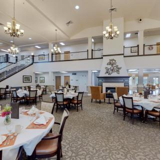 Spacious dining area with elegant chandeliers and neatly arranged tables.