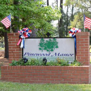 Welcome to Pinewood Manor, adorned with decorative flags and greenery.