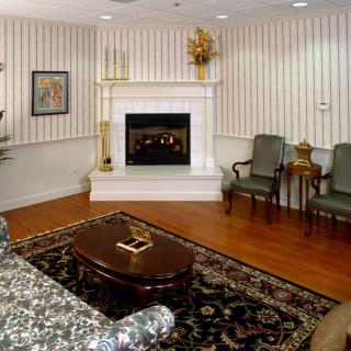 A traditionally decorated living room with a fireplace and classic furniture.