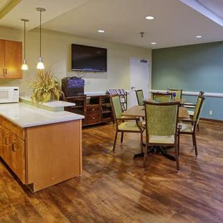 A modern kitchen and dining area with wooden floors and cozy furnishings.