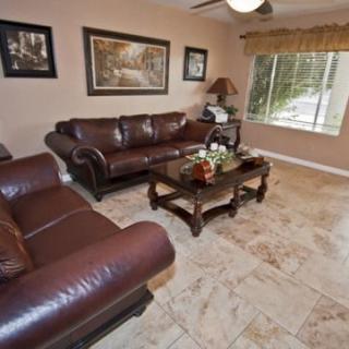 A cozy living room with leather sofas, a wooden coffee table, and decorative artwork.