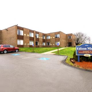Exterior view of a residential apartment building with a sign.