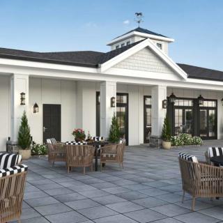 A modern outdoor patio with wicker seating and decorative plants.