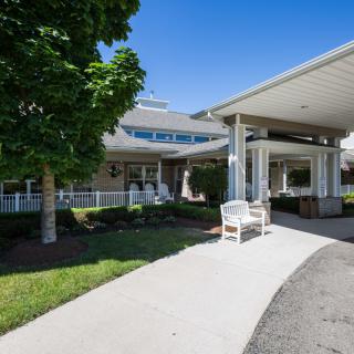 A well-maintained building entrance with a covered walkway and surrounding greenery.