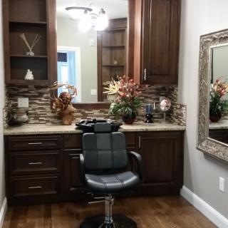 A well-equipped salon space featuring a barber chair, elegant cabinetry, and decorative elements.