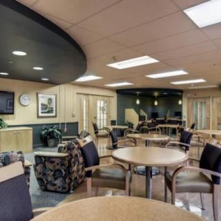 A modern waiting area featuring comfortable seating and tables.