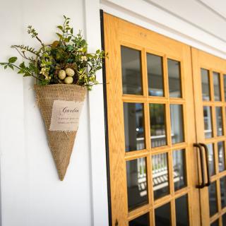 A welcoming entrance with wooden doors and a decorative floral arrangement on the wall.
