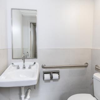 A modern and clean bathroom with a sink, toilet, and mirror.