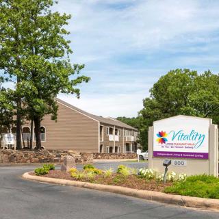 A residential building with a sign reading 'Victory' surrounded by greenery and trees.