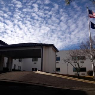 A view of a building with flags flying under a cloudy sky.