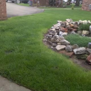 A beautifully maintained lawn featuring a rocky garden edge.