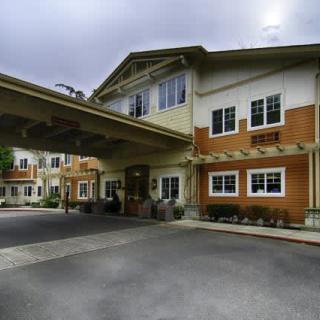 A modern building entrance with an overhanging structure and driveway.