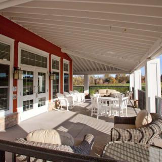 A cozy outdoor patio with comfortable seating under a covered roof.
