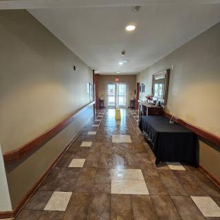 A well-lit hallway leading to an entrance with decorative tile flooring.