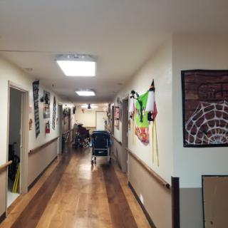 A brightly lit hallway in a healthcare facility, adorned with colorful decorations on the walls.