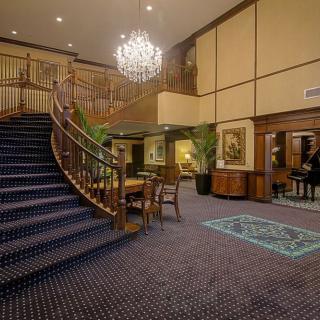A luxurious hotel lobby with a grand staircase and chandelier.