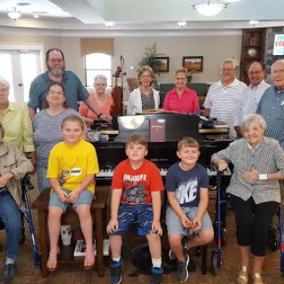 A joyful family gathering around the piano, capturing moments across generations.