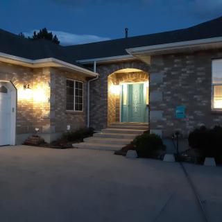 A brick house entrance warmly lit during the evening.