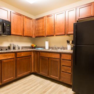 A modern kitchen with wooden cabinets and black appliances.