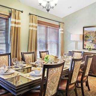 A well-decorated dining room with an elegant table setting and warm lighting.