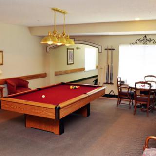 A spacious game room featuring a red pool table and dining area.