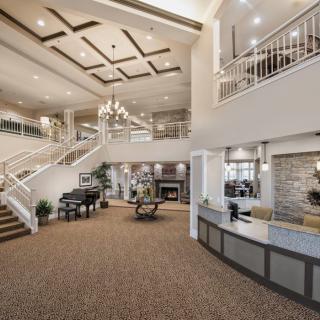 A spacious and elegantly designed lobby with a grand staircase and chandelier.