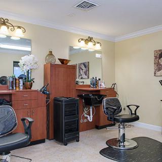 A cozy hair salon interior featuring styling chairs and mirrors, with hairdressing tools neatly arranged on wooden counters.