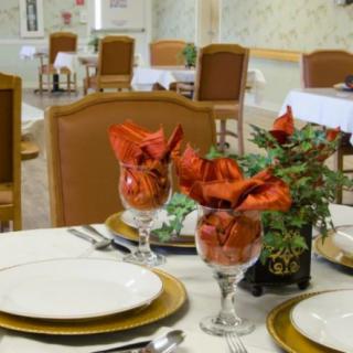A beautifully decorated dining table with elegant tableware and floral arrangements in a restaurant setting.