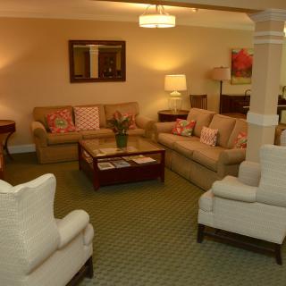 A cozy living room with comfortable sofas, a central coffee table, and warm lighting.