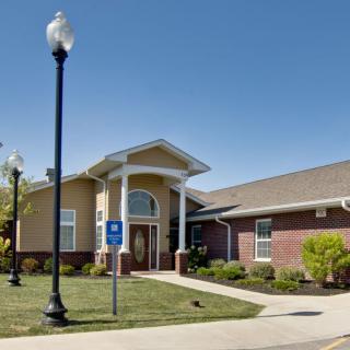 A brick building with a well-maintained lawn and clear blue sky overhead.