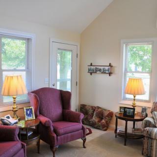 A cozy living room with traditional decor, featuring armchairs and warm lighting.