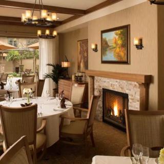 A cozy dining area in a restaurant featuring a warm fireplace and elegant decor.