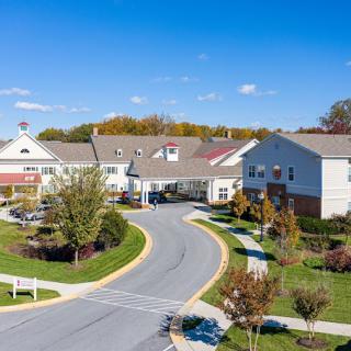 Aerial view of a residential complex with landscaped gardens and a winding road.