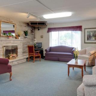 A cozy living room with a fireplace, sofas, a television, and a coffee table.