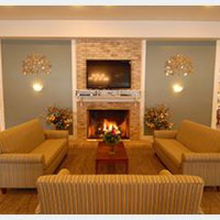 A cozy living room featuring a fireplace, television, and comfortable sofas.