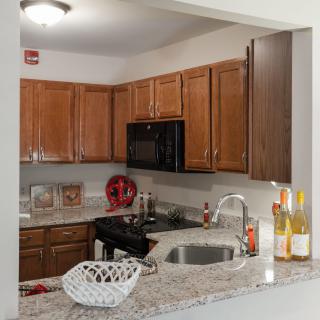 A modern kitchen with wood cabinets and granite countertops.