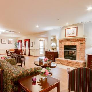 A cozy living room featuring a brick fireplace, comfortable seating, and warm decor.