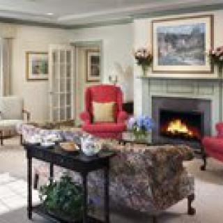 A cozy living room with a fireplace, comfortable seating, and traditional decor.