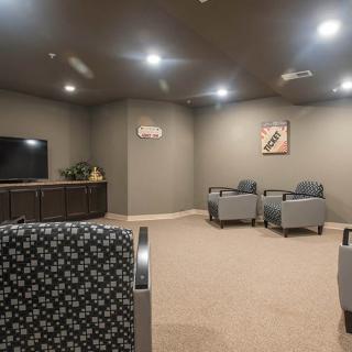 A modern lounge area with chairs, a television, and neutral decor.