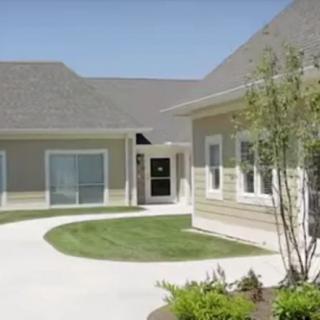 A view of a residential courtyard with buildings and a well-maintained lawn.