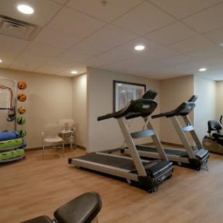 A well-equipped indoor gym featuring treadmills and workout stations.