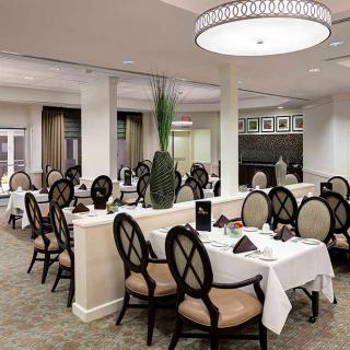 An elegant dining room setup with neatly arranged tables and chairs, ready for guests.