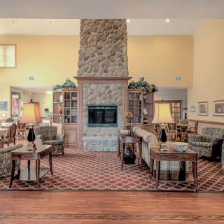 A cozy living room with a stone fireplace and comfortable seating.