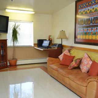 A cozy living room with a sofa, television, and a painting.