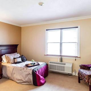 A cozy bedroom featuring a neatly made bed and elegant furnishings.
