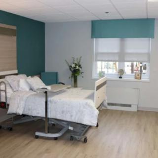 A modern and clean hospital room with a single bed and window.