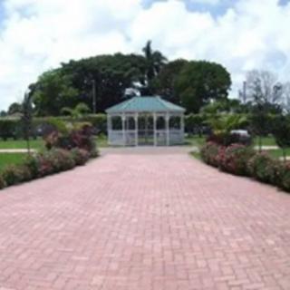 A scenic pathway leads to a gazebo surrounded by lush gardens.