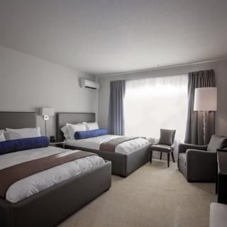 A modern hotel room featuring two comfortable beds and stylish furnishings.