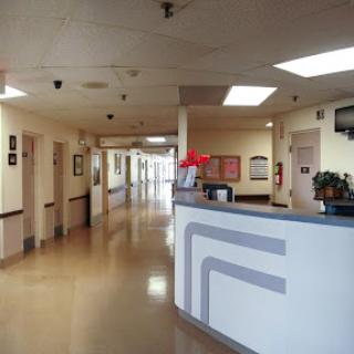 A view of the reception area in a hospital with a long corridor leading to patient rooms.